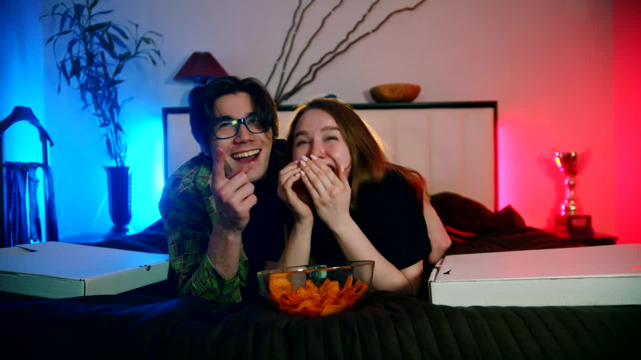 Stock Video A Boy And A Girl Laughing While Watching Television Live Wallpaper for PC