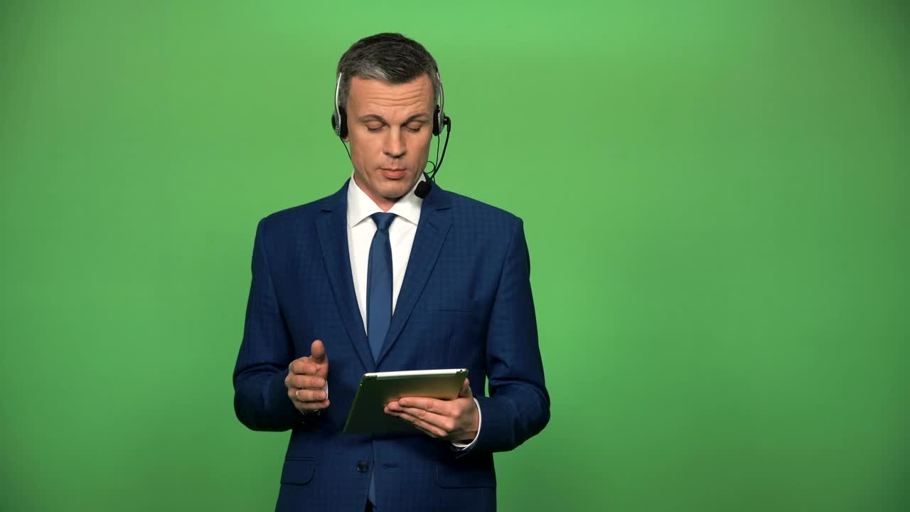 Stock Video A Businessman With A Headset And A Tablet Talking Live Wallpaper for PC