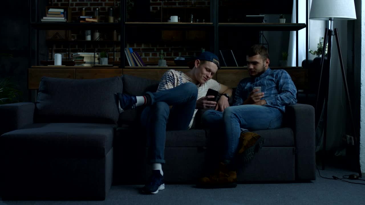 Stock Video A Couple Of Friends Sitting Laughing With Their Cell Phones Live Wallpaper for PC