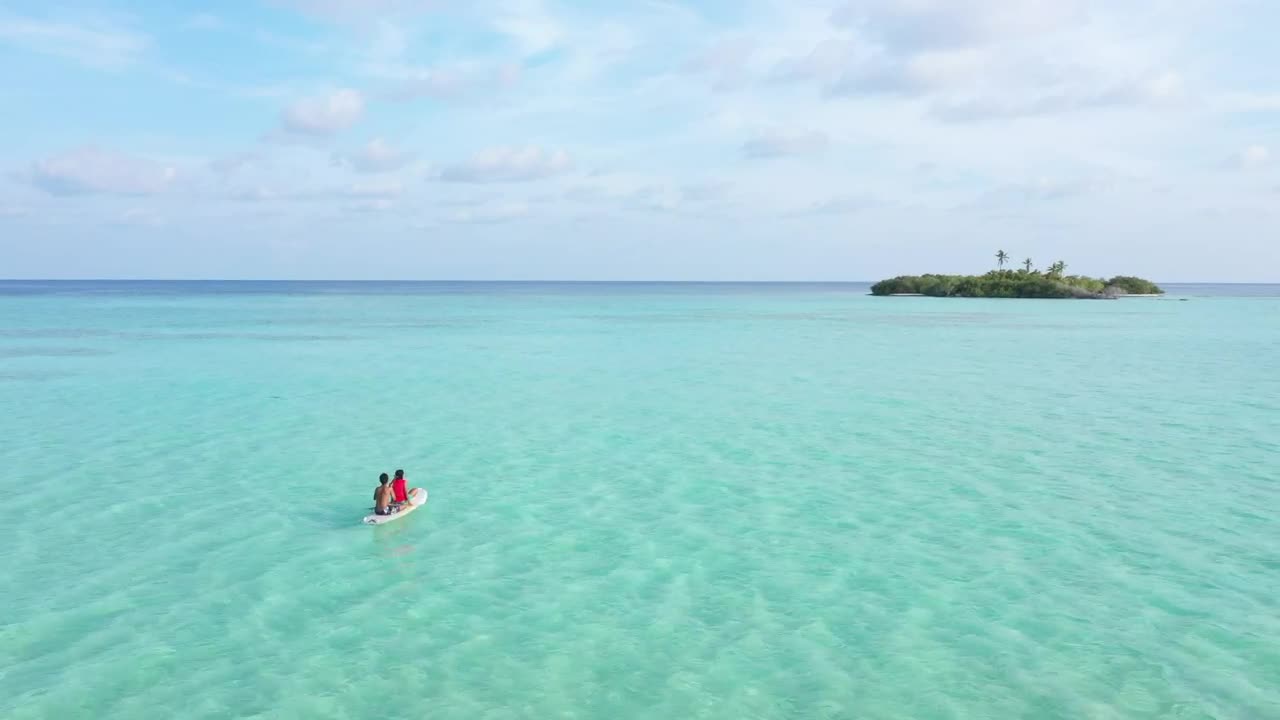 Stock Video A Couple Seated On A Paddle Board In The Sea Live Wallpaper for PC