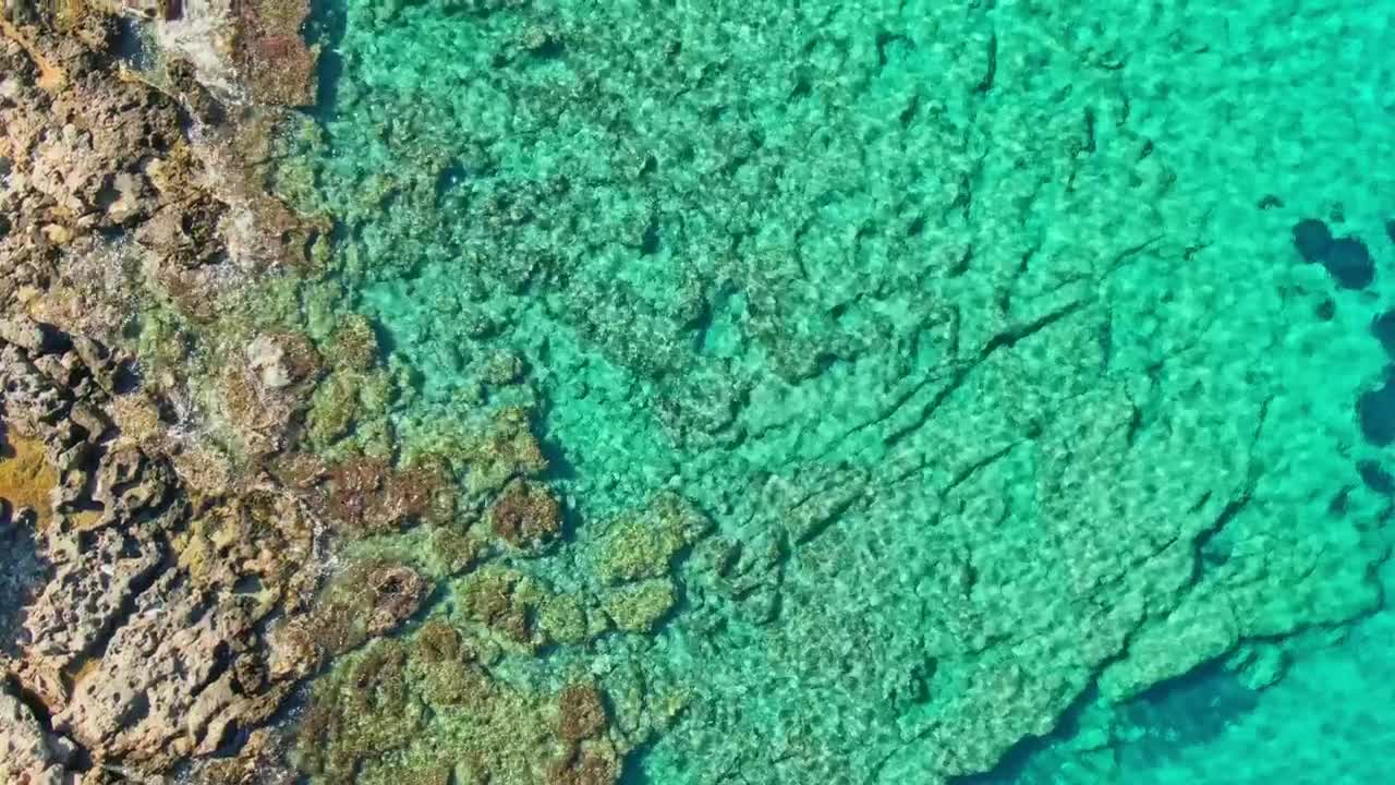 Stock Video Aerial View Of Bright Blue Rocky Sea Shallows Live Wallpaper for PC