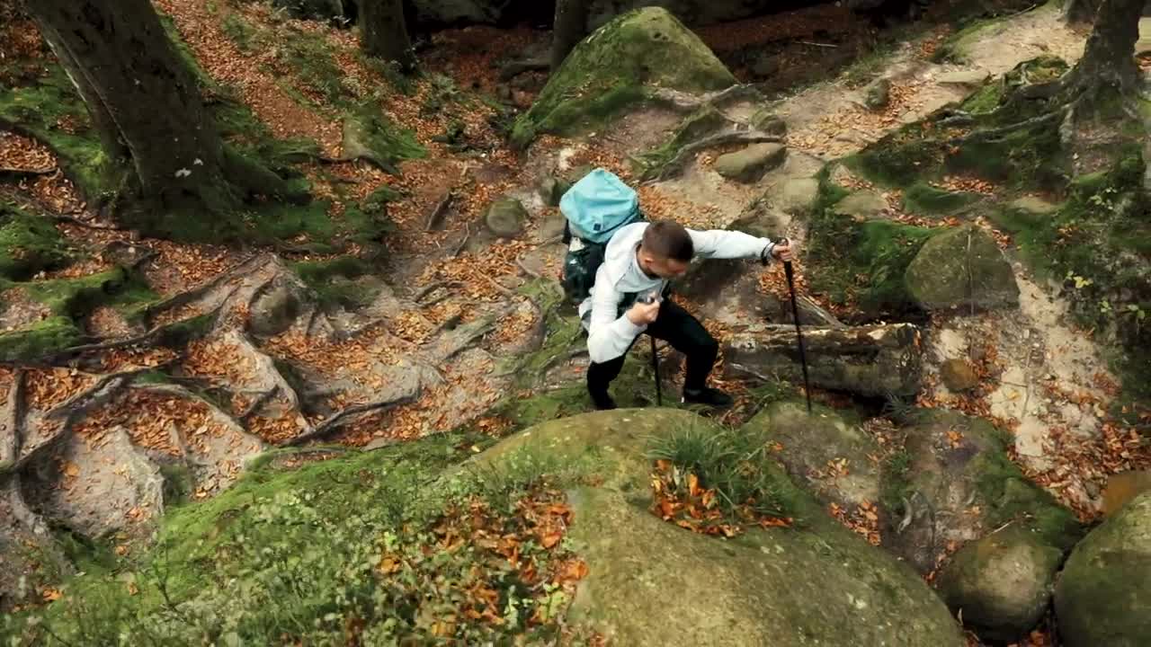 Stock Video Aerial View Of Man Climbing Mossy Rocks On Hike Live Wallpaper for PC