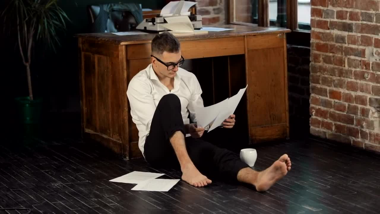 Stock Video Barefoot Writer Sits On Floor Reading Manuscript Live Wallpaper For PC