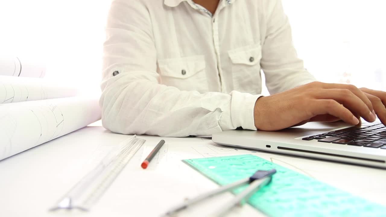 Stock Video Architect Working On Blueprints And His Laptop Live Wallpaper For PC