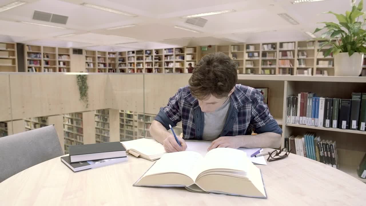Stock Video A Young Man Studying In The Library Live Wallpaper For PC