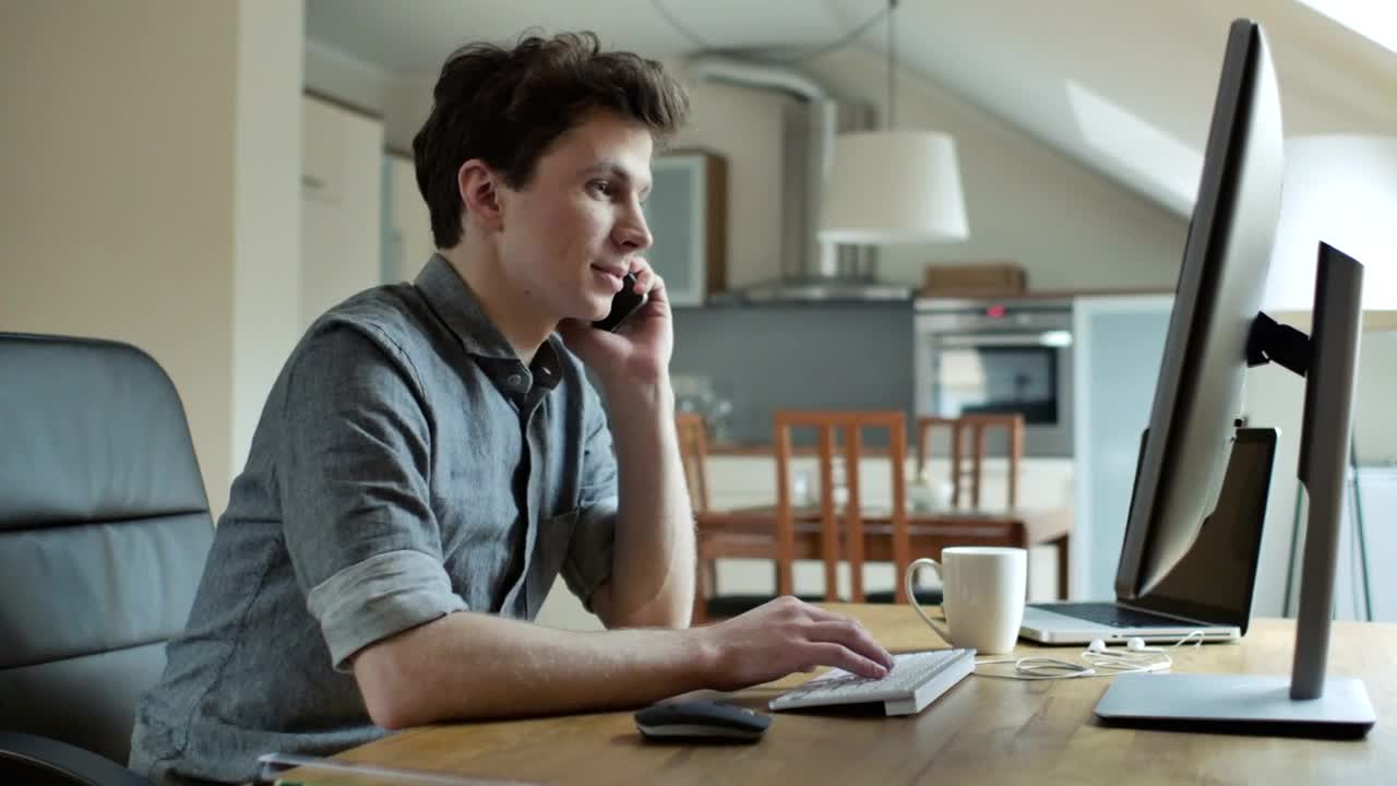Stock Video A Young Man Talking On The Phone Working On The Live Wallpaper For PC