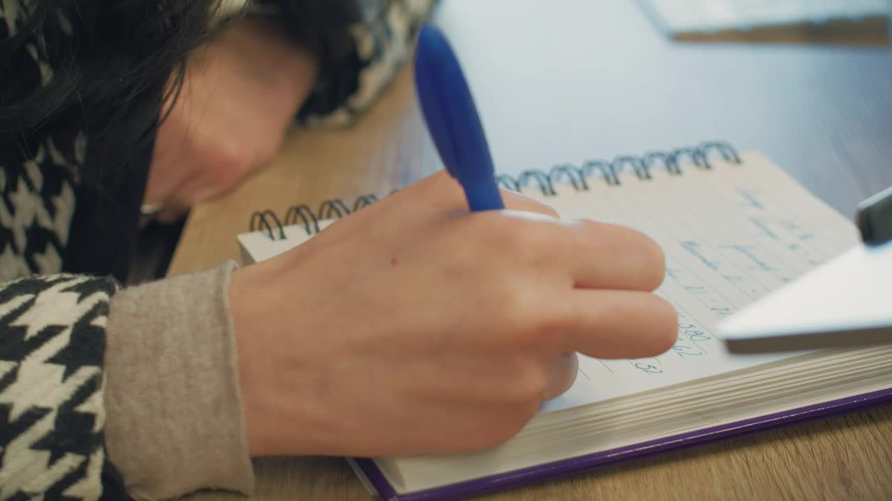 Stock Video A Woman Writing In Her Spiral Notebook Live Wallpaper For PC