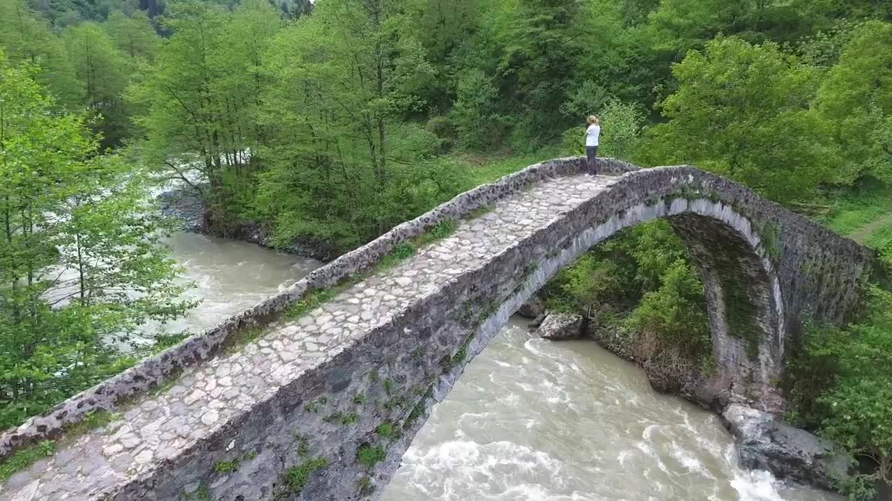 Stock Video A Woman Standing In An Old Stone Bridge Above The Live Wallpaper For PC