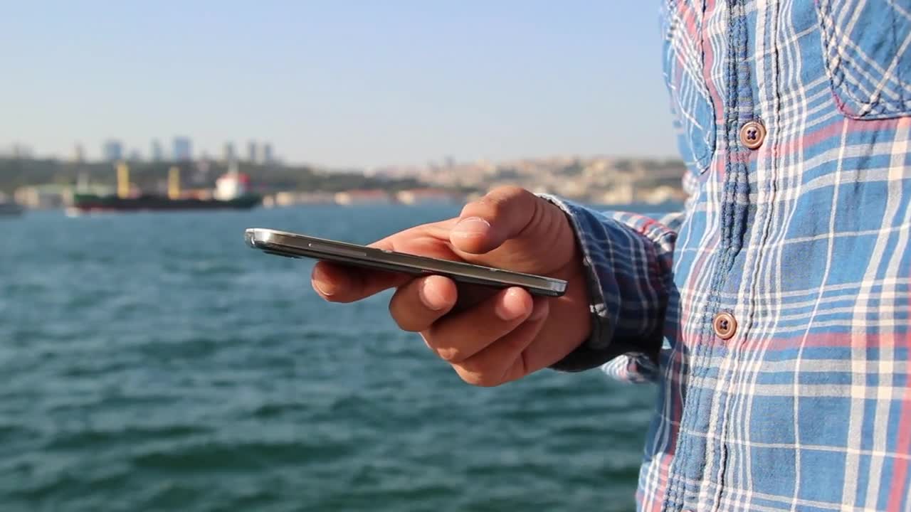 Stock Video A Mans Hand Holding A Cell On A Boat Live Wallpaper For PC
