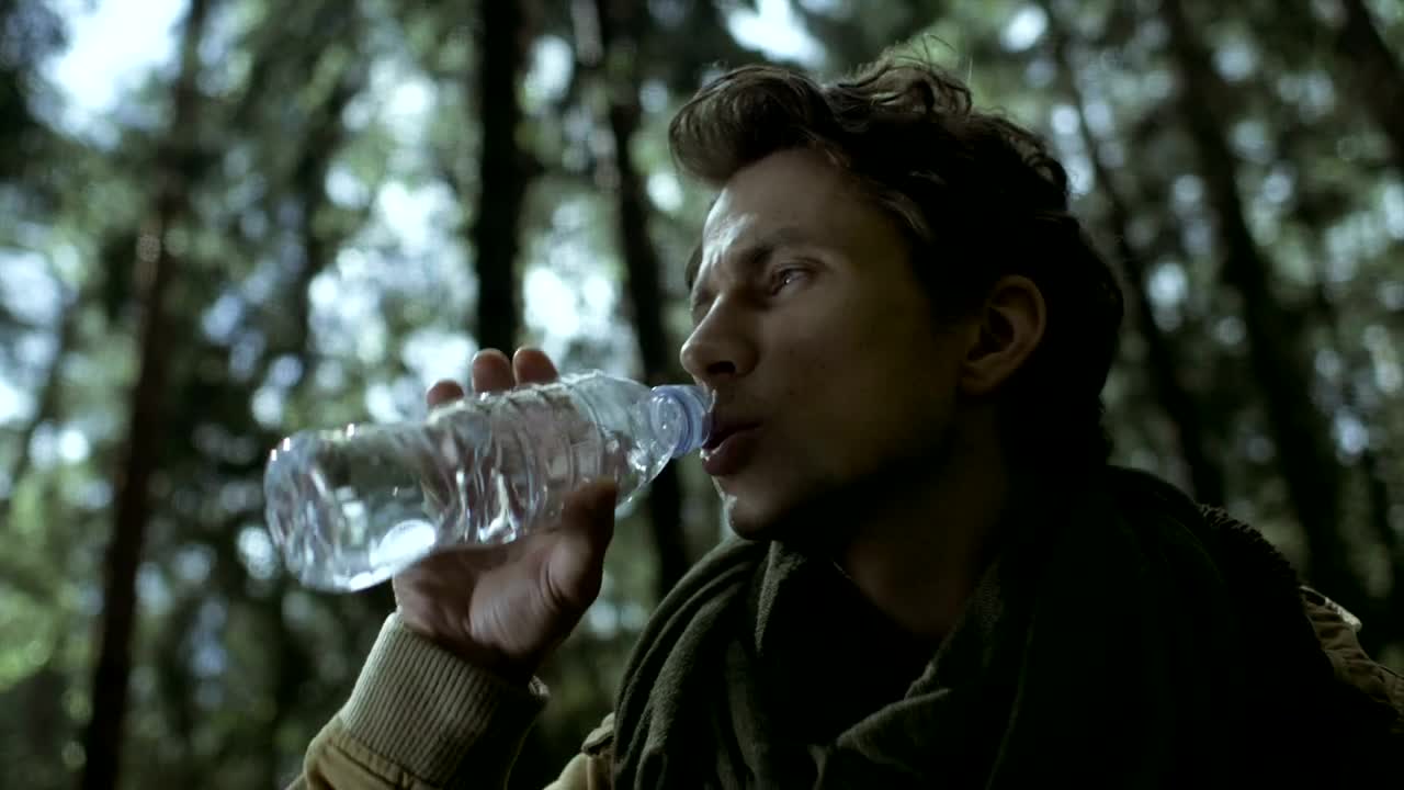 Stock Video A Man Drinks Water From A Bottle In The Woods Live Wallpaper For PC