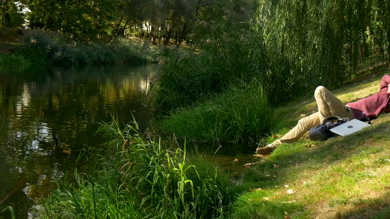 Stock Video Boy On A Computer On The Shore Of A River Live Wallpaper For PC