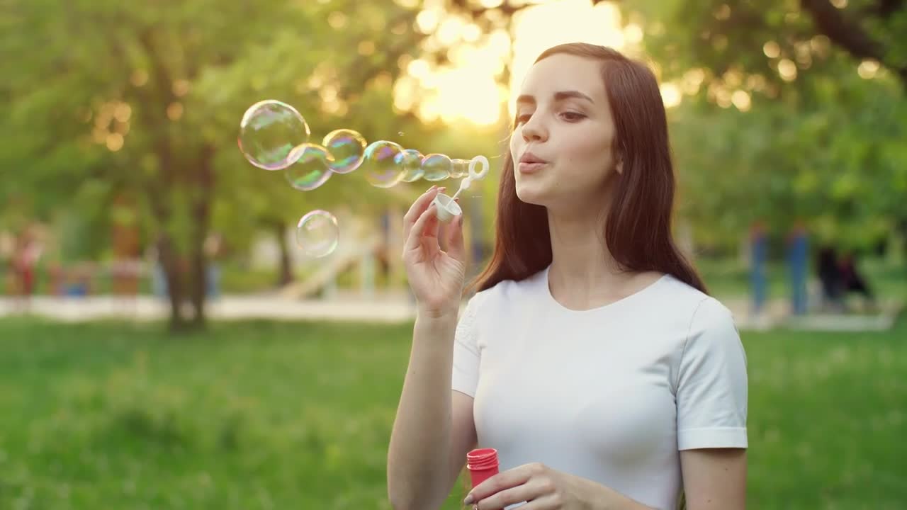 Video Stock Cheerful Girl Blowing Soap Bubbles In A Park Live Wallpaper For PC