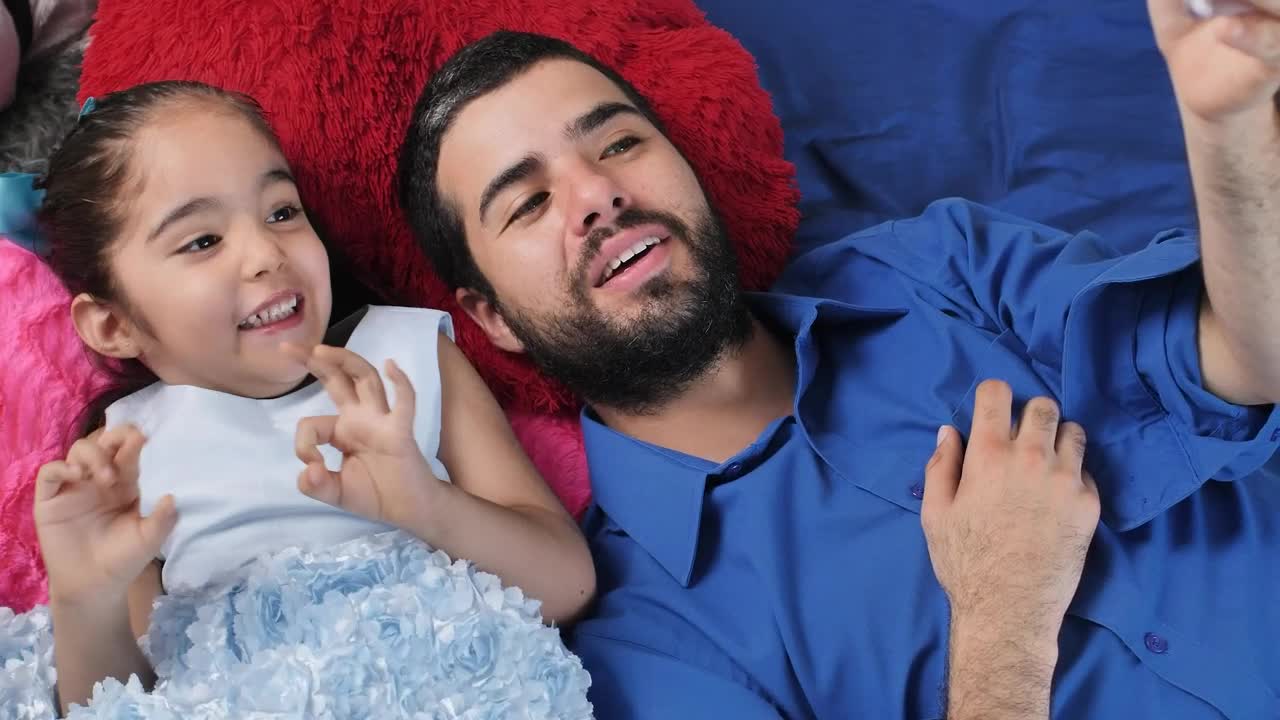Stock Video Dad And Daughter Lying Excitedly Watching A Video On A Live Wallpaper For PC