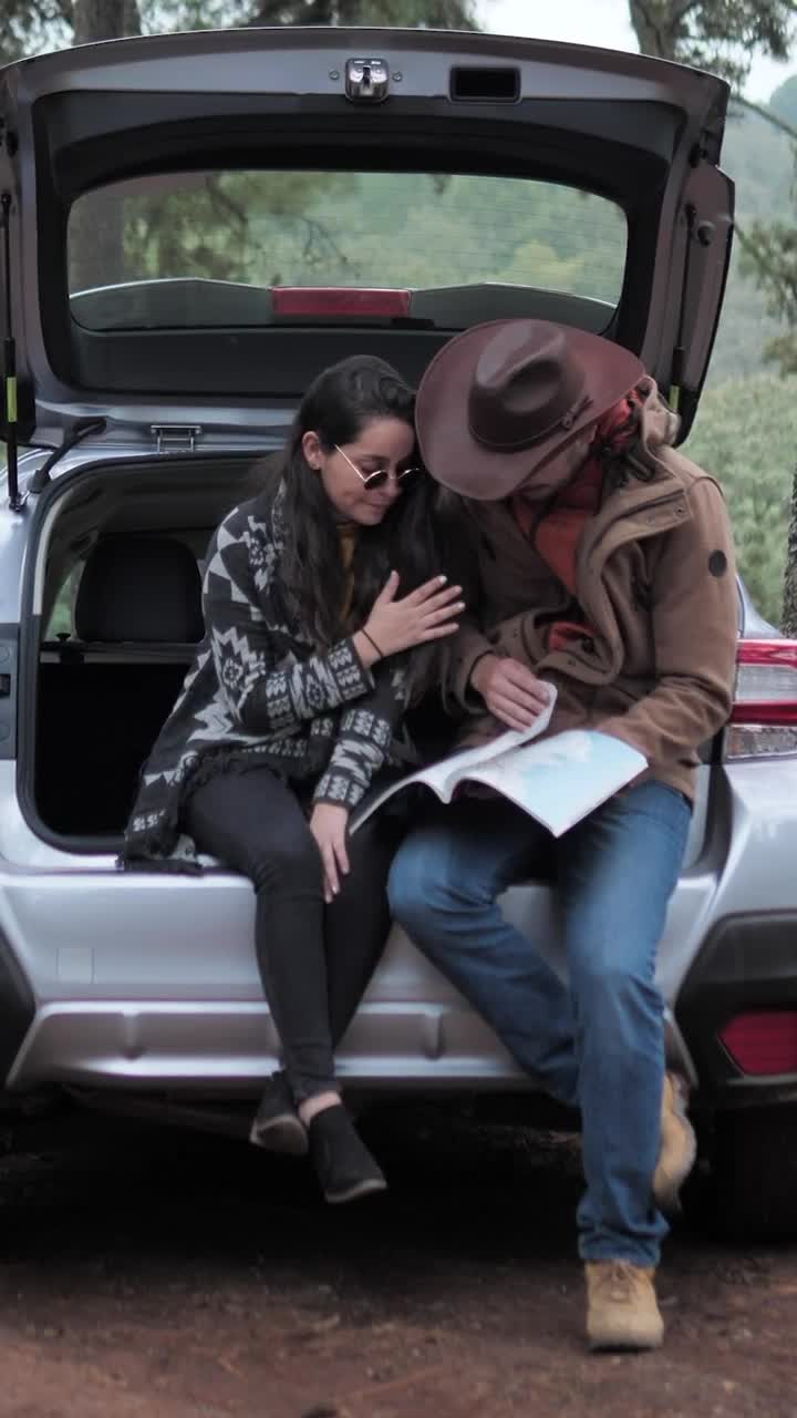 Stock Video Couple Watching A Map In The Trunk Of A Car Live Wallpaper For PC