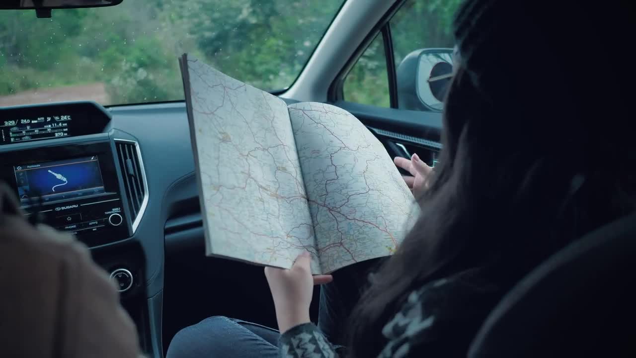 Stock Video Couple Of Adventurers Reading A Map Inside A Car Live Wallpaper For PC