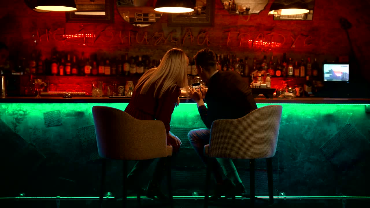 Stock Video Couple Checking Something In A Smartphone In A Bar Live Wallpaper For PC