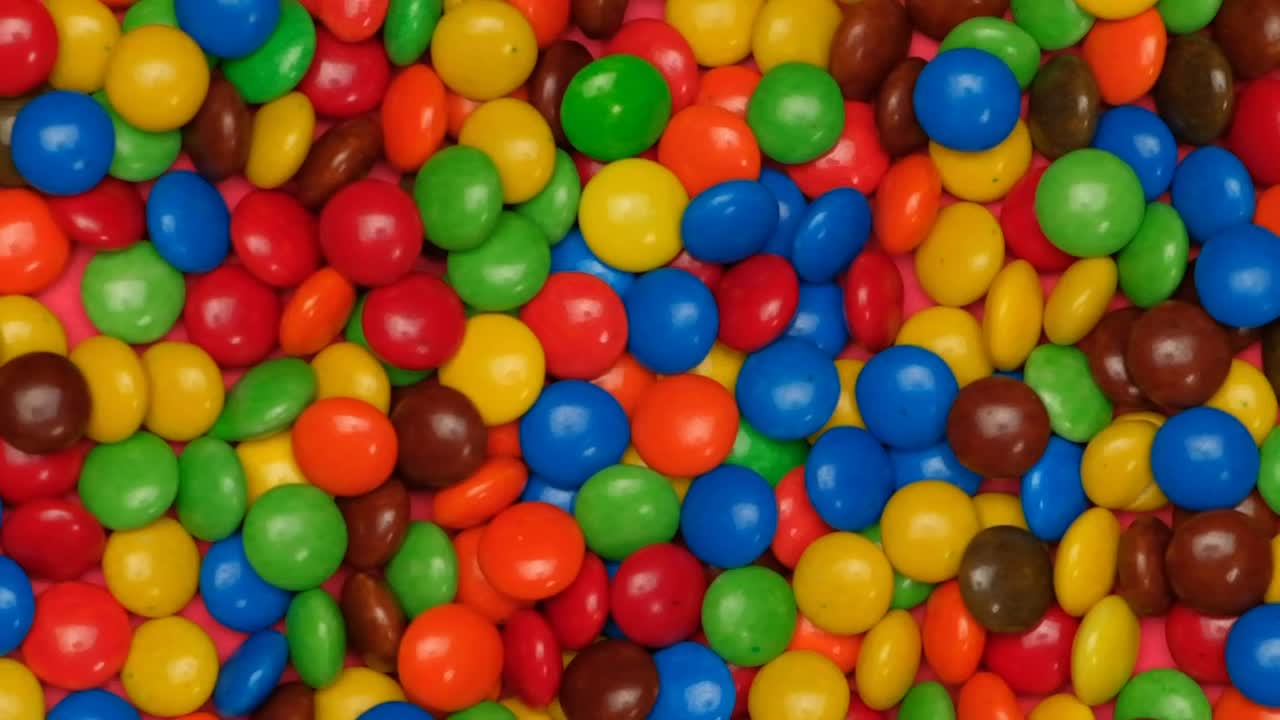 Stock Video Colored Chocolates Jumping On A Pink Background Live Wallpaper For PC