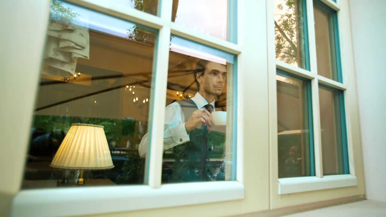Stock Video Elegant Man Drinking From A Mug While Looking Out Live Wallpaper For PC