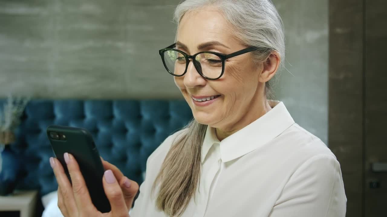 Stock Video Elderly Woman Smiles While Using Mobile App Live Wallpaper For PC