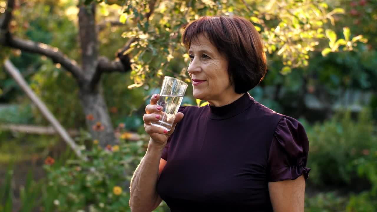 Stock Video Elderly Woman Drinking Water In Her Home Garden Live Wallpaper For PC