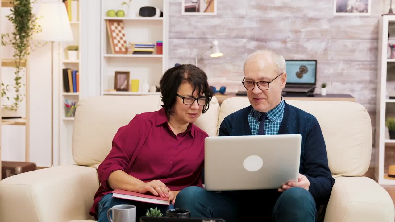 Stock Video Elderly Couple On Sofa With Laptop Shopping Online Live Wallpaper For PC