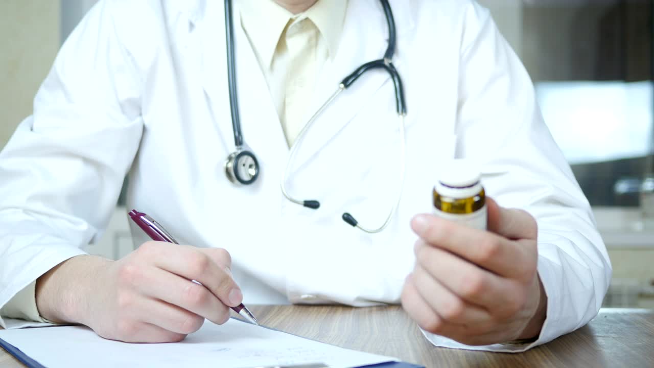Stock Video Doctor Writing A Prescription Holding A Medicine Container Live Wallpaper For PC