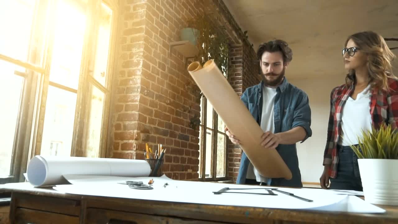 Stock Video Designers Unroll Plans Onto Desk In Studio Live Wallpaper For PC