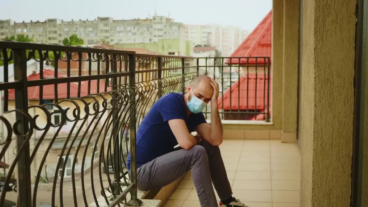 Stock Video Depressed Man Wearing Mask Sits On Balcony In Covid Lockdown Live Wallpaper For PC