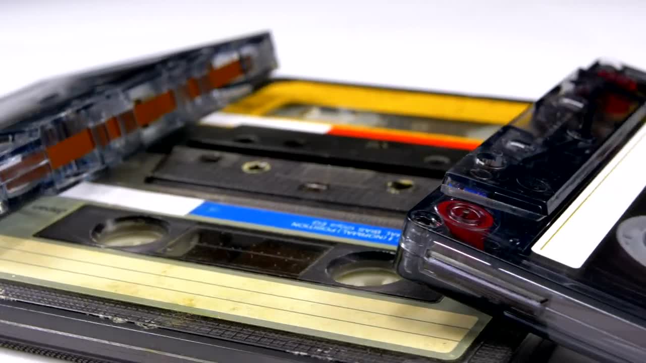 Stock Video Four Audio Cassettes Rotating On A White Surface Live Wallpaper For PC