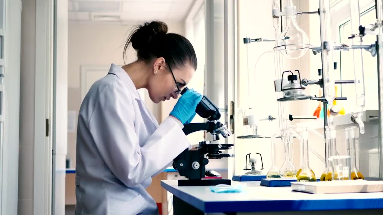 Stock Video Female Scientist Observing Through A Microscope Live Wallpaper For PC