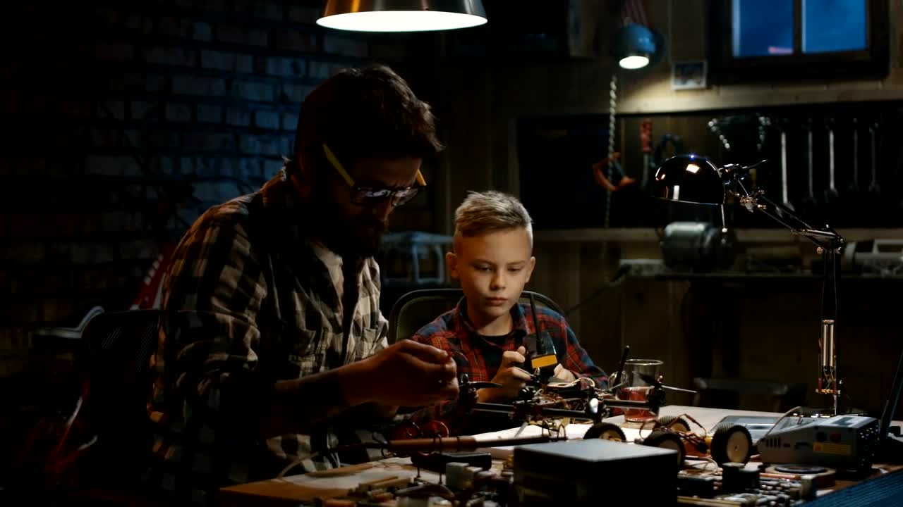 Stock Video Father And Son Repairing A Drone In The Garage Live Wallpaper For PC