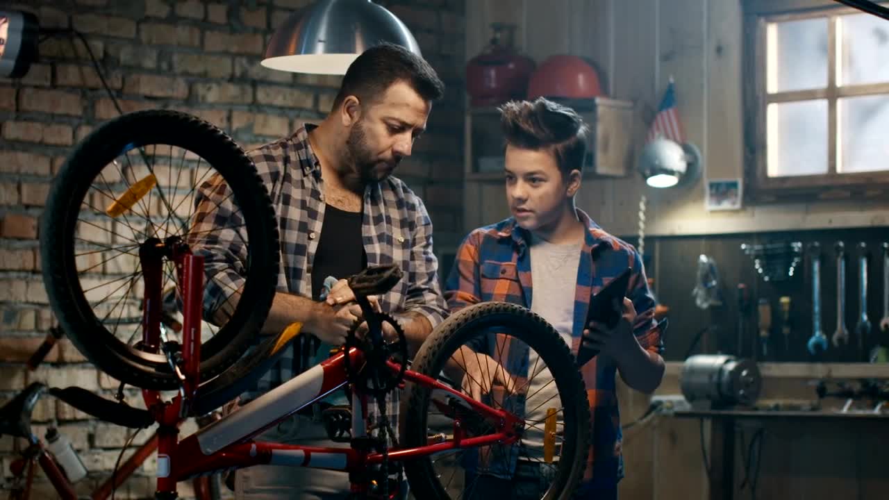 Stock Video Father And Son Repairing A Bike With Tutorial Live Wallpaper For PC