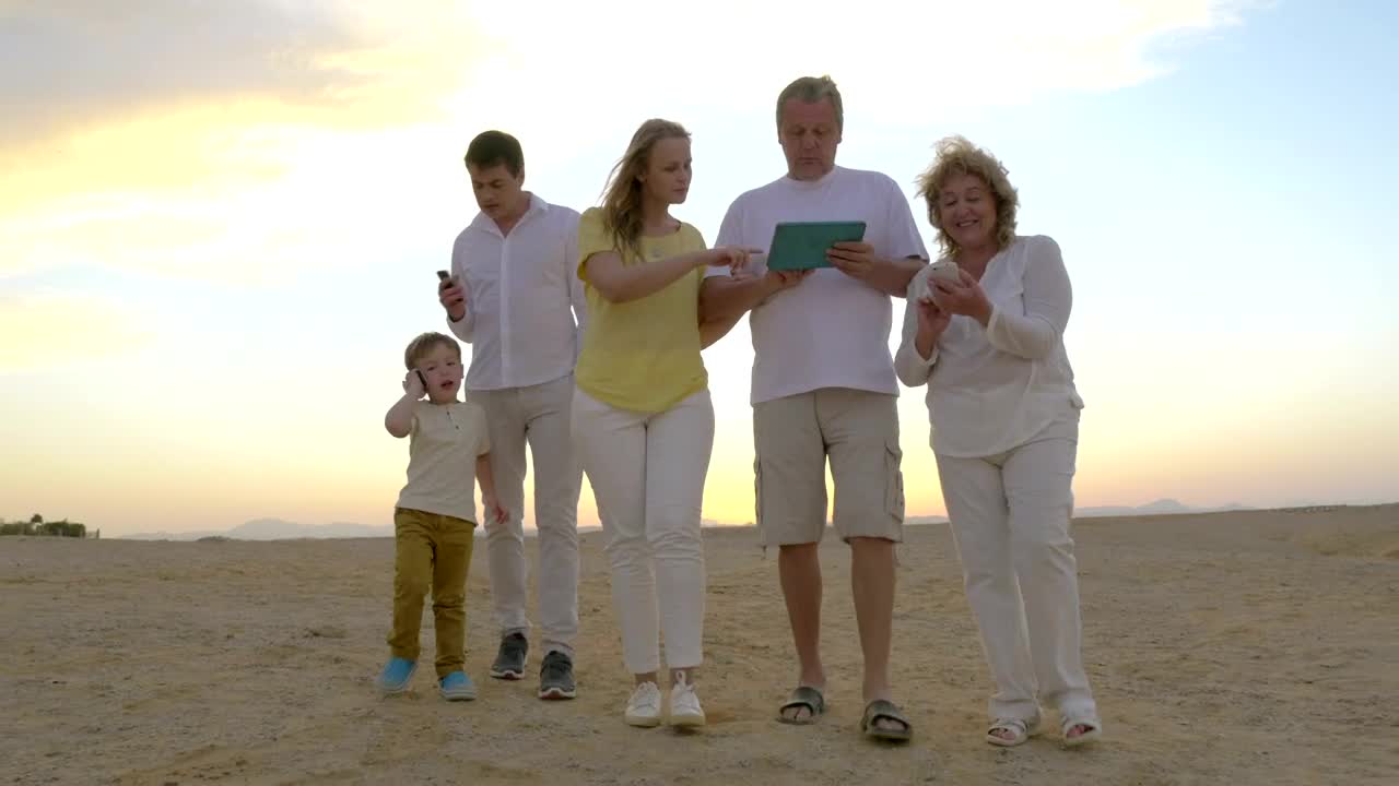 Stock Video Family Walking Along The Beach With A Tablet Live Wallpaper For PC