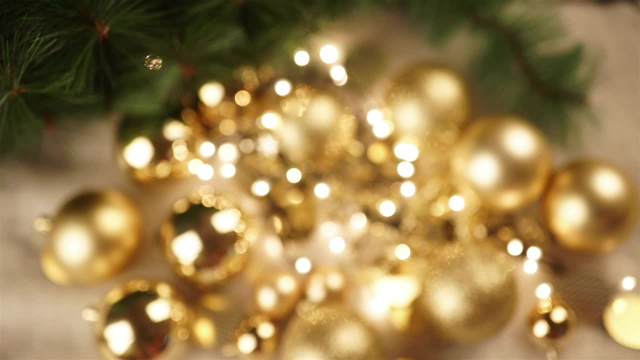 Stock Video Hand Holds Out Christmas Ornament With Gold Bokeh Background Live Wallpaper For PC