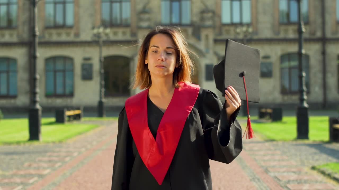 Stock Video Graduate Student In Gown Holding Hat Outside University Live Wallpaper For PC