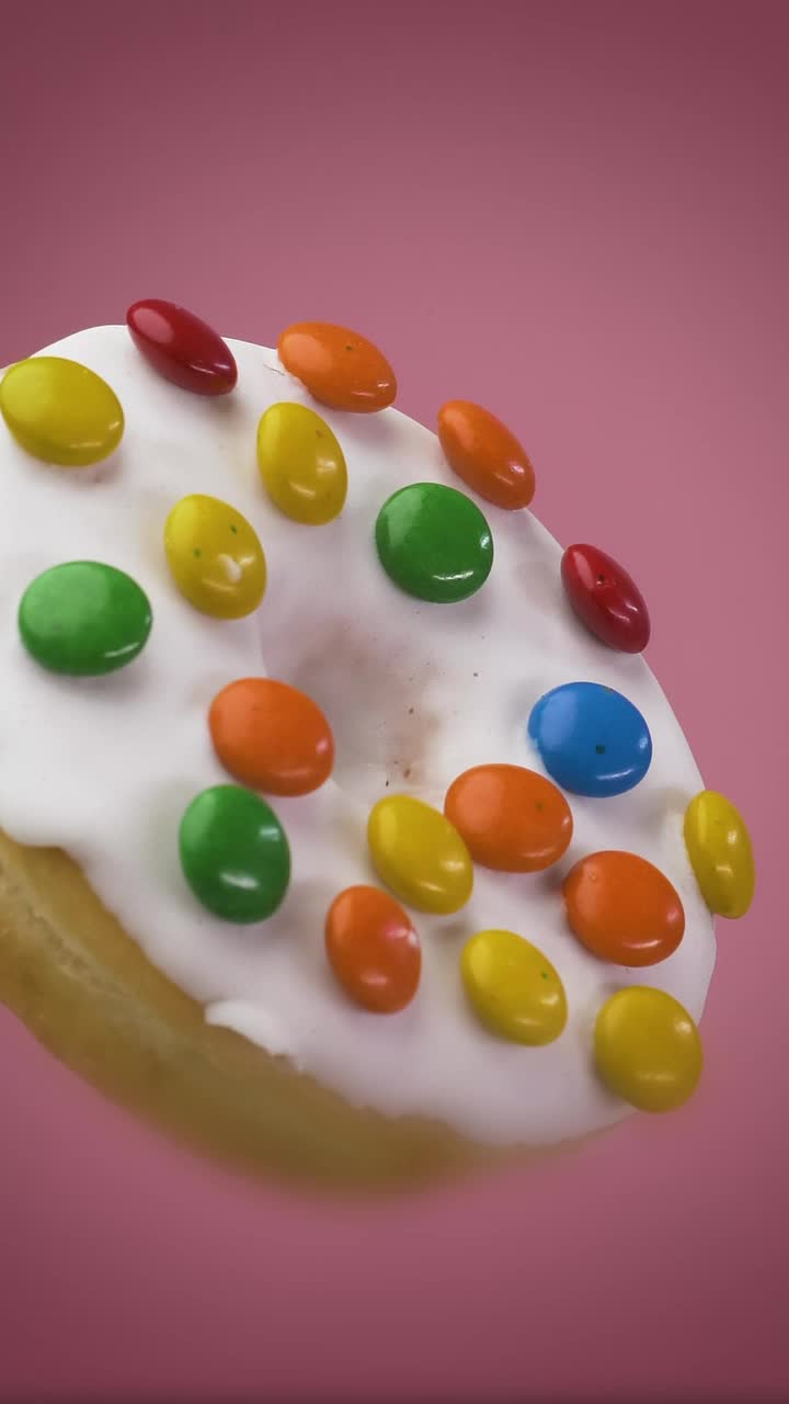 Stock Video Glazed Donut With Colored Chocolates On A Pink Background Live Wallpaper For PC