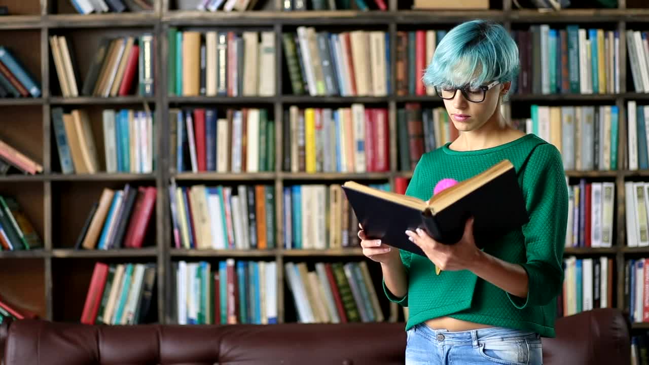 Stock Video Girl With Glasses Reading A Book In A Library Live Wallpaper For PC