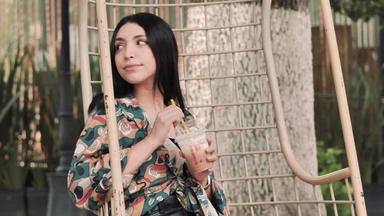 Stock Video Girl Sitting In A Hanging Chair Enjoying A Cold Coffee Live Wallpaper For PC