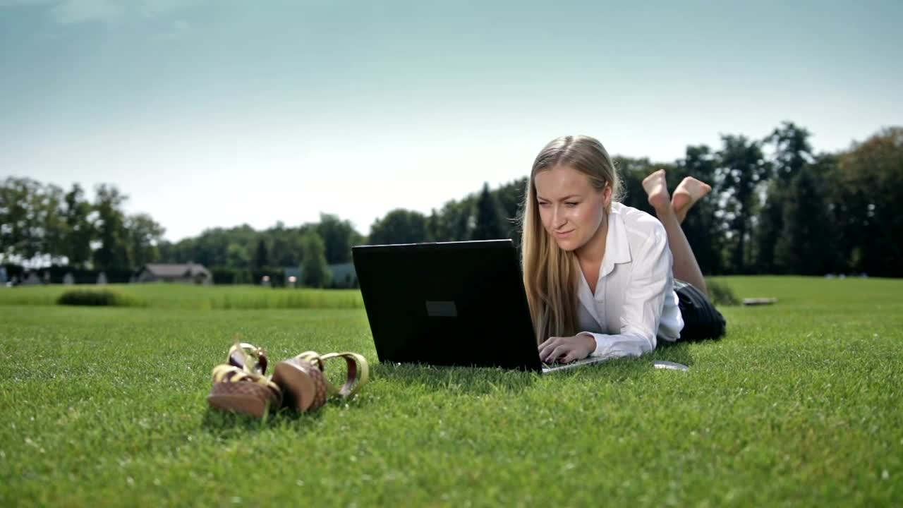 Stock Video Girl Lying On The Grass Working On Her Computer Live Wallpaper For PC