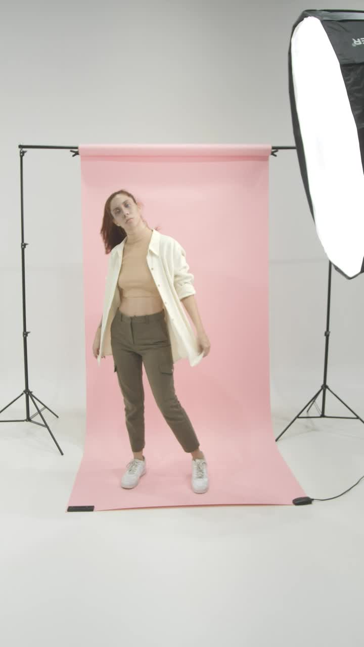 Stock Video Girl In A Photographic Set Modeling On A Pink Background Live Wallpaper For PC