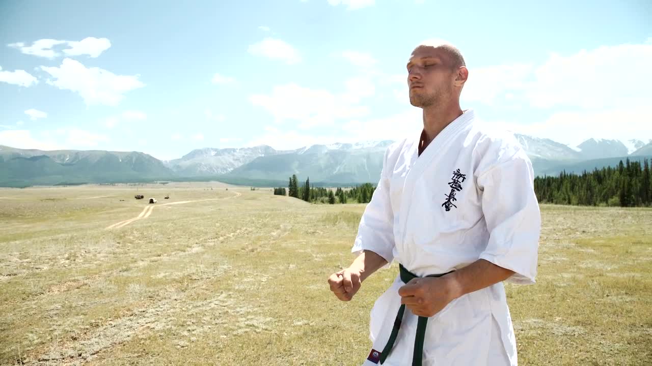 Stock Video Karate Black Belt Meditating In Open Field Landscape Animated Wallpaper