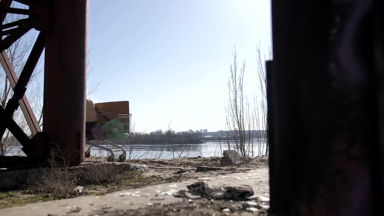 Stock Video Homeless Man With A Shopping Cart Under A Bridge Animated Wallpaper