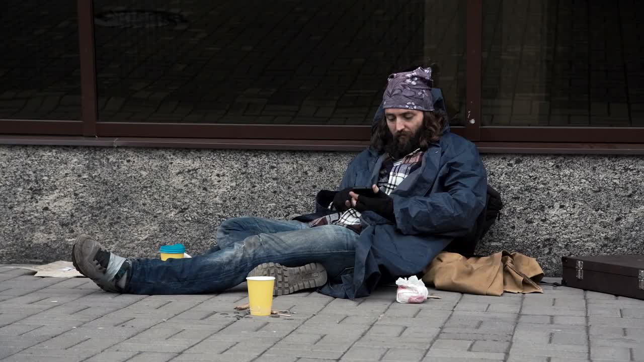 Stock Video Homeless Man Using Smartphone On The Street Animated Wallpaper