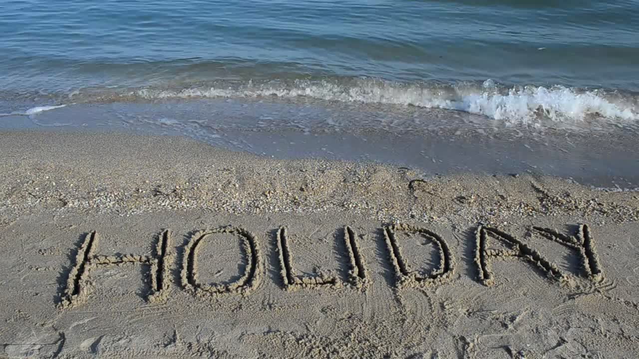 Stock Video Holiday Written In The Sand Near The Sea Animated Wallpaper