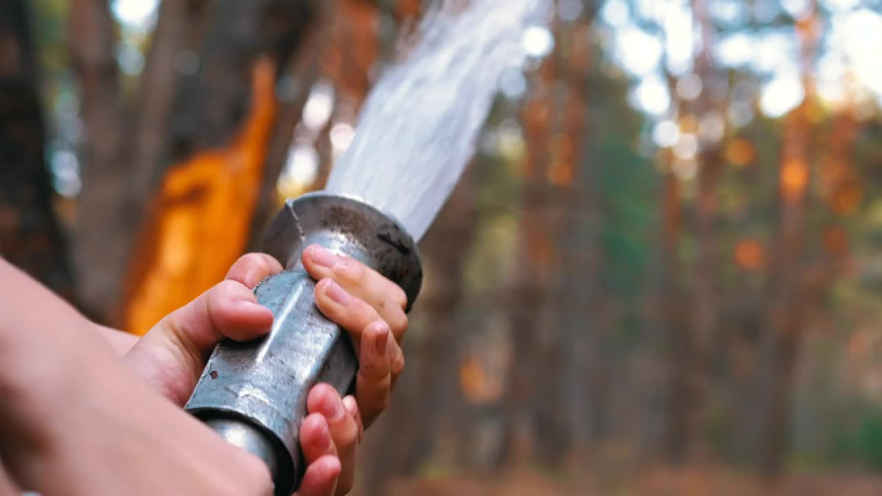 Stock Video Holding A Fire Hose Throwing Water Animated Wallpaper