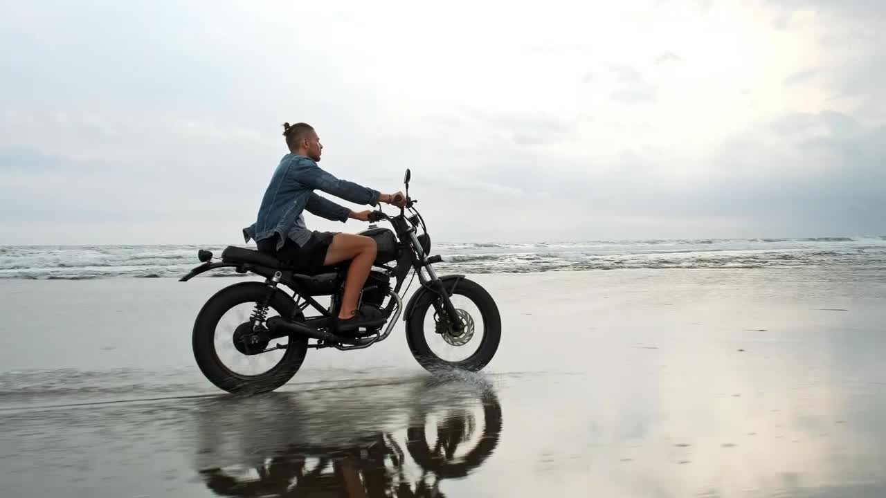 Stock Video Hipster Biker Riding A Motorcycle Near The Seashore Animated Wallpaper