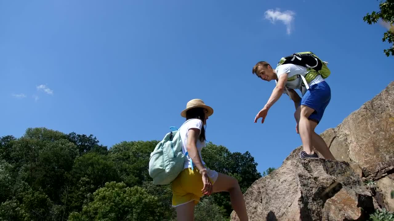 Stock Video Hiking Man Helping His Partner Climb Animated Wallpaper