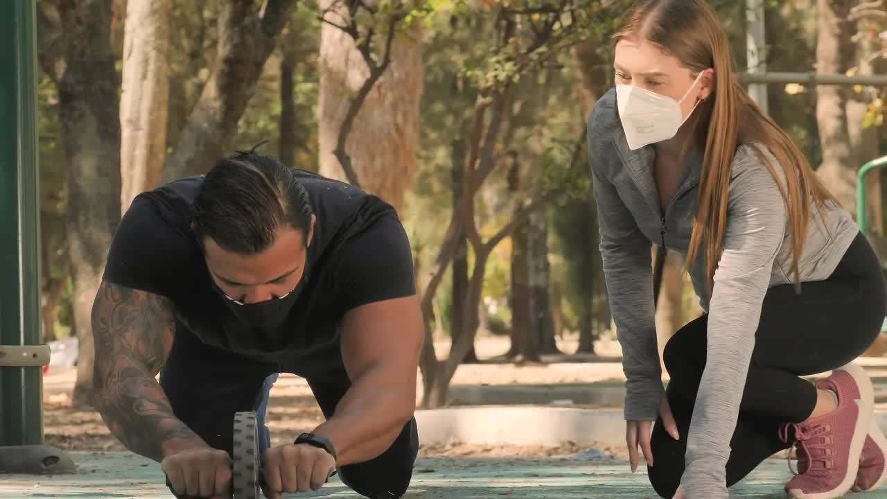 Stock Video Healthy Couple Doing Exercises At A Park Animated Wallpaper