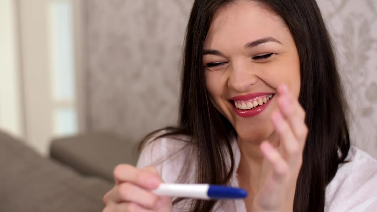 Stock Video Happy Woman Smiles When Checking That She Is Pregnant Animated Wallpaper