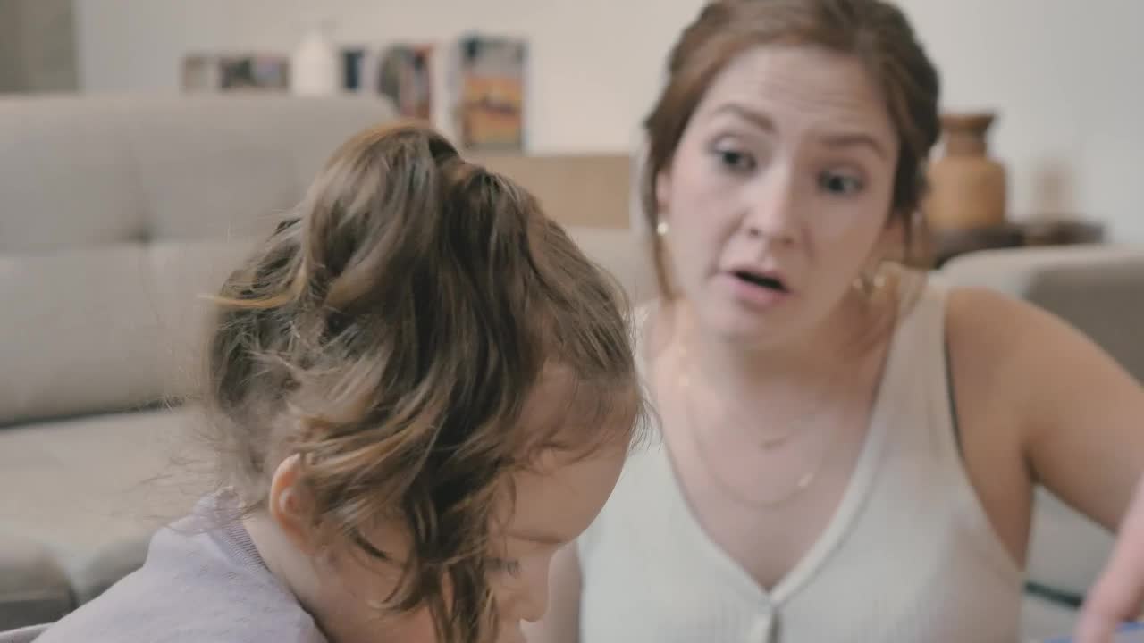 Stock Video Happy Girl Puts Together A Puzzle With Her Mother Animated Wallpaper